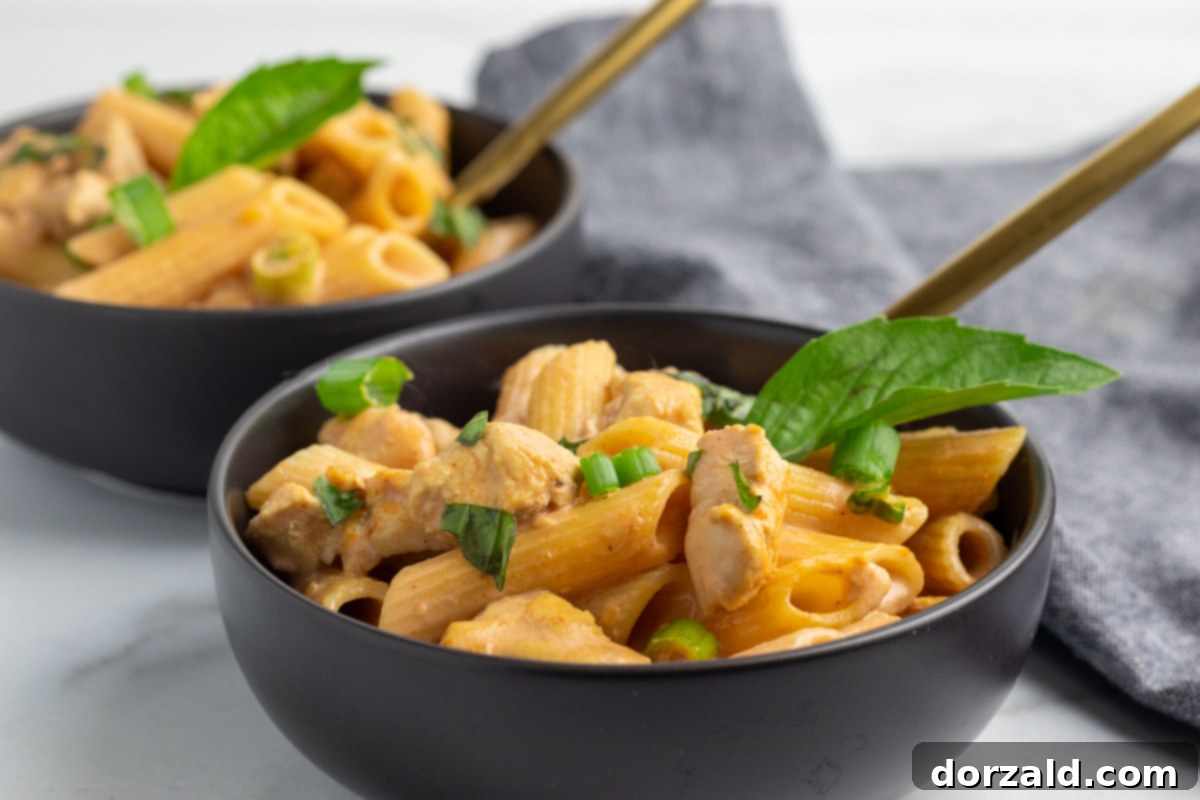 Creamy Chicken Curry Pasta 2 A close-up shot of Chicken Curry Pasta in a bowl, garnished with fresh herbs, showcasing the creamy sauce and tender chicken pieces.