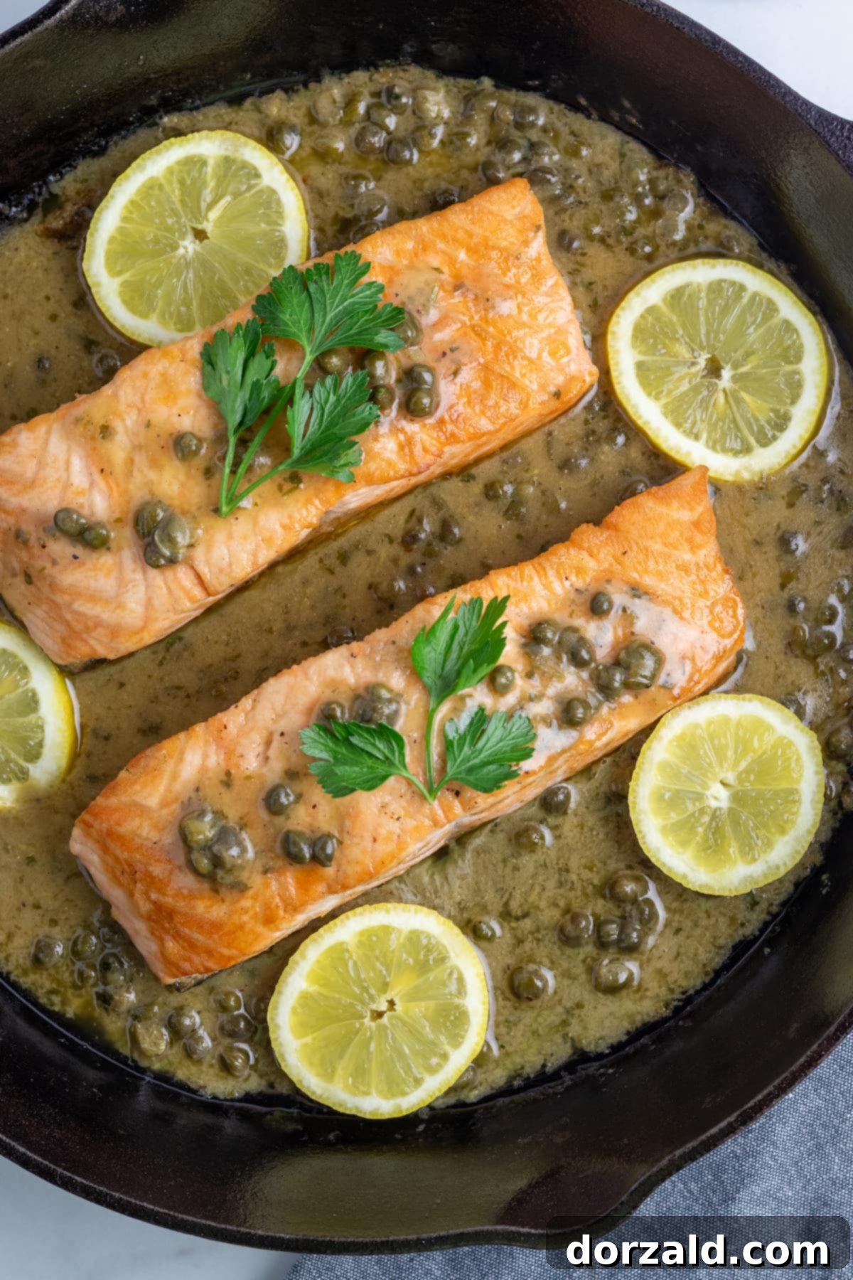 A vibrant display of fresh ingredients for Salmon Piccata Pasta, including salmon fillets, lemons, capers, and herbs.