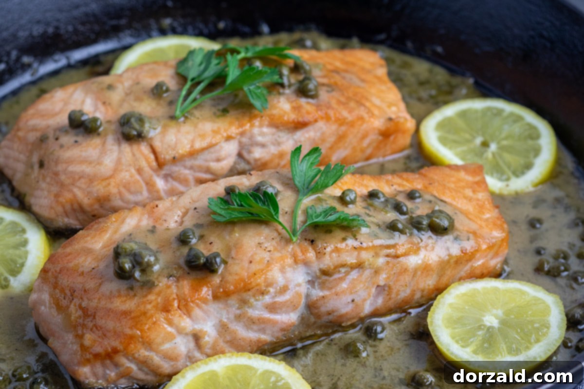 Lemony caper sauce simmering in a large skillet, ready for salmon and pasta.