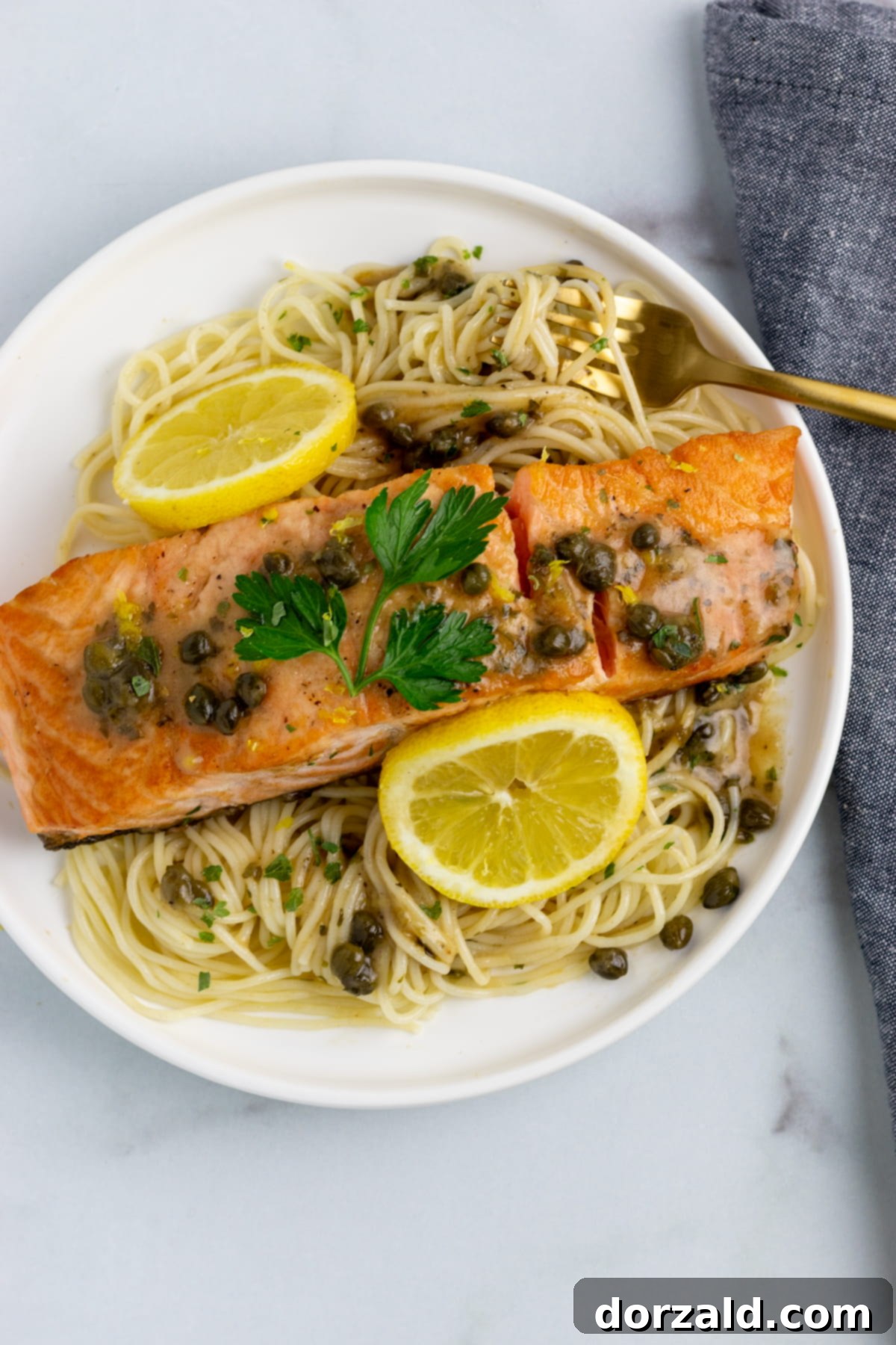 A beautifully plated dish of Salmon Piccata Pasta, garnished with fresh parsley and lemon, ready to be enjoyed.