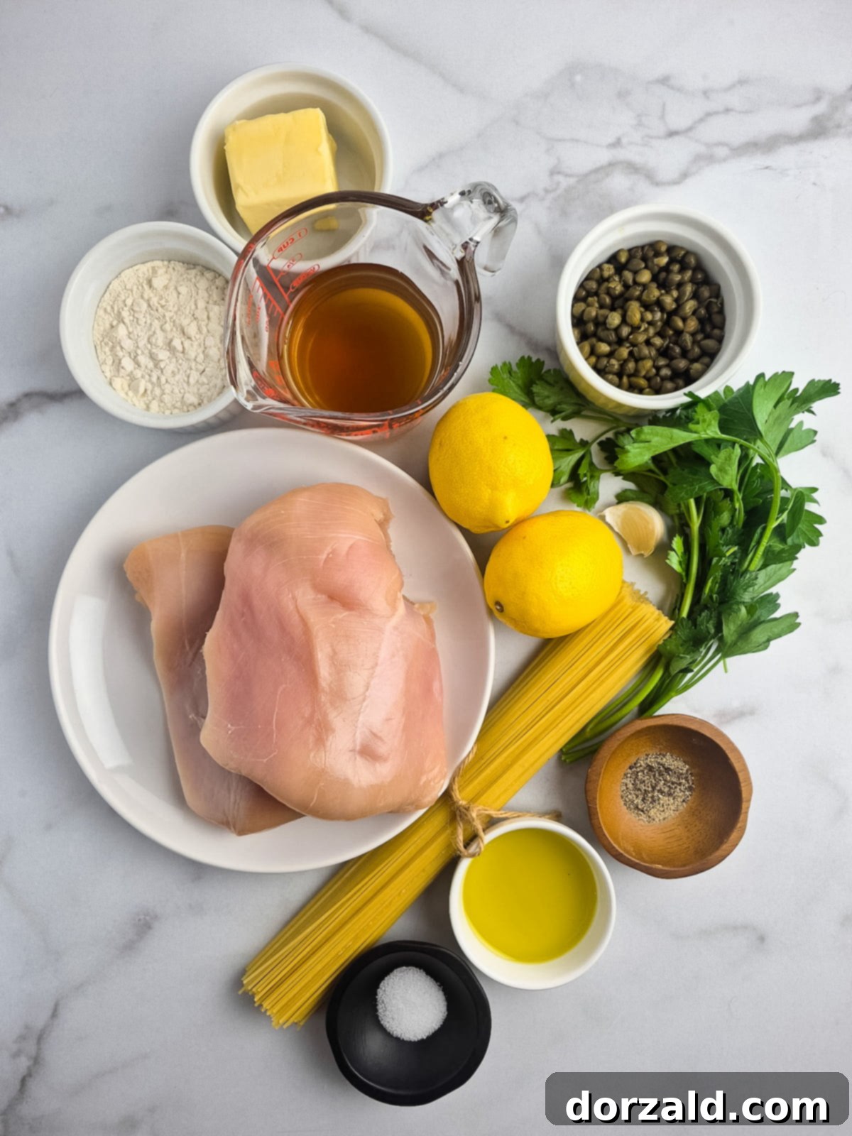 Ingredients for Dairy-Free Gluten-Free Chicken Piccata laid out on a counter