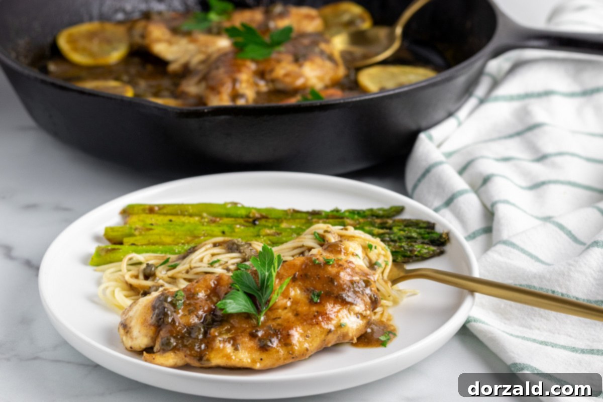 Dairy-Free Gluten-Free Chicken Piccata in a skillet with lemon slices and parsley
