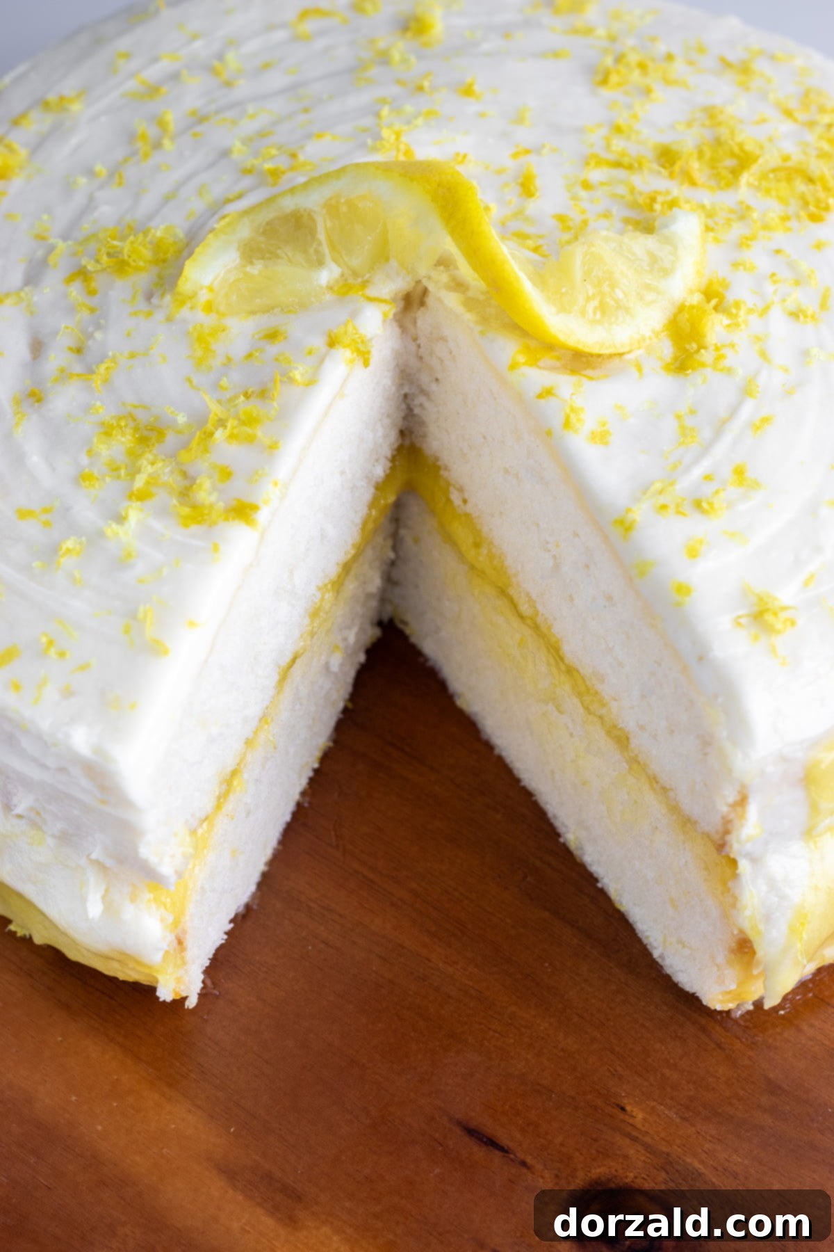 Dairy-free lemon buttercream frosting being whipped in a bowl with an electric mixer.