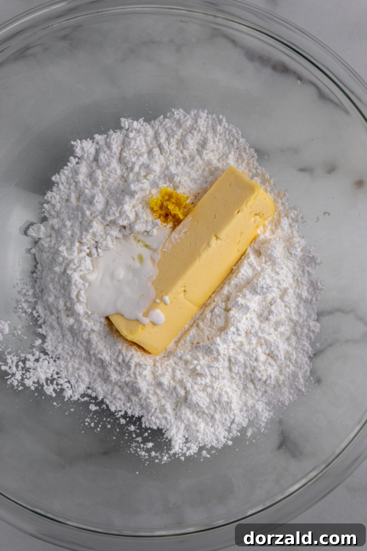 Lemon being zested over a bowl