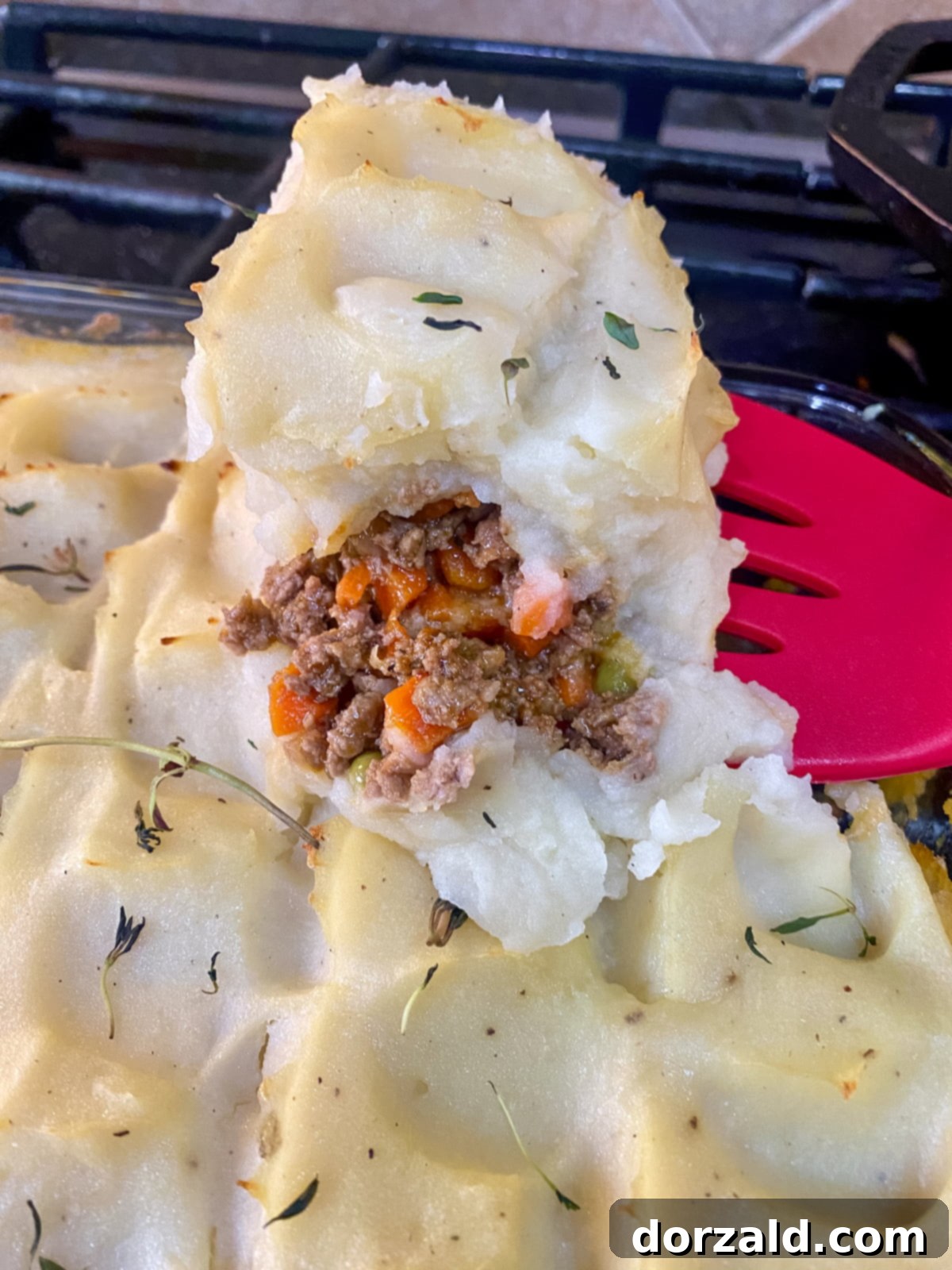 Close-up of the rich and savory meat and vegetable filling of a Dairy-Free Shepherd's Pie before being topped with mashed potatoes.