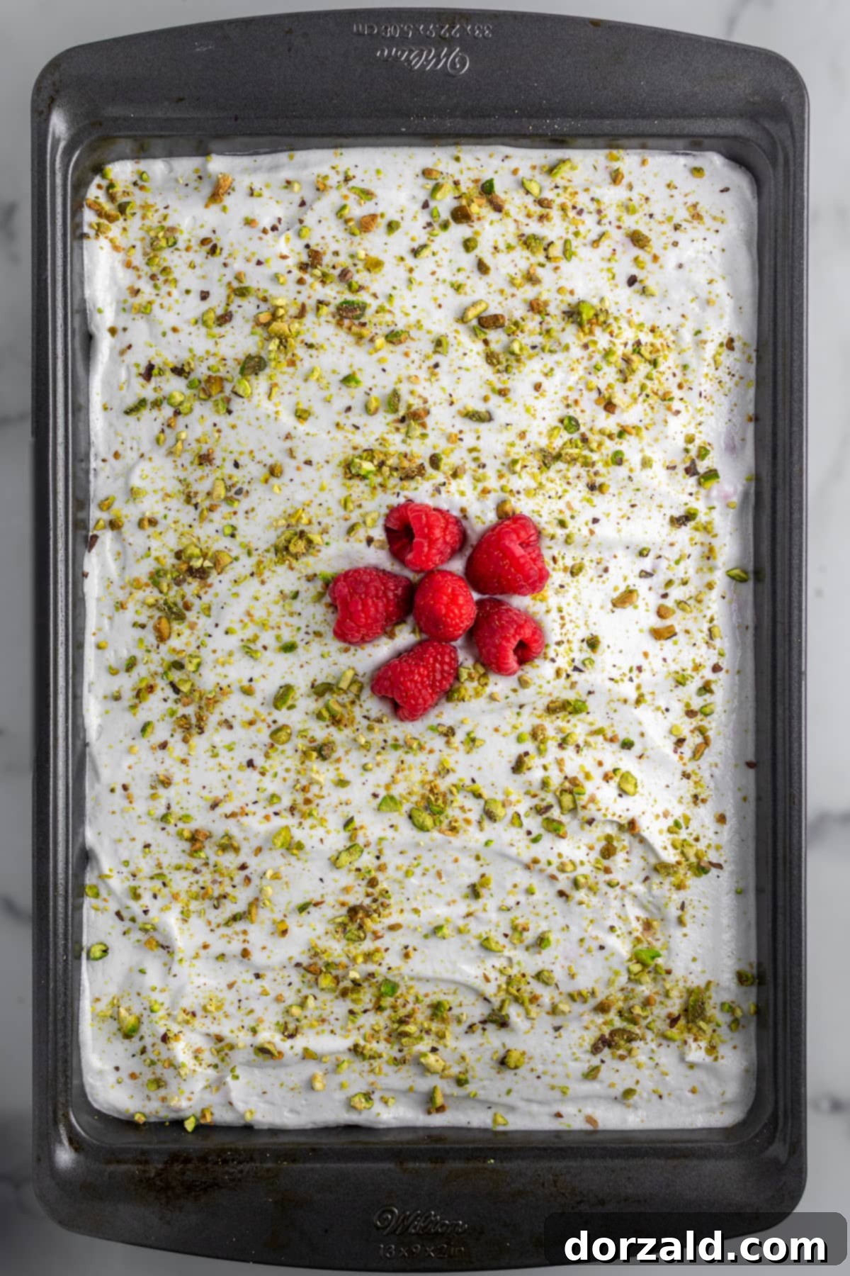 Simple Pistachio Raspberry Cake 8 A beautifully decorated slice of pistachio raspberry sheet cake.