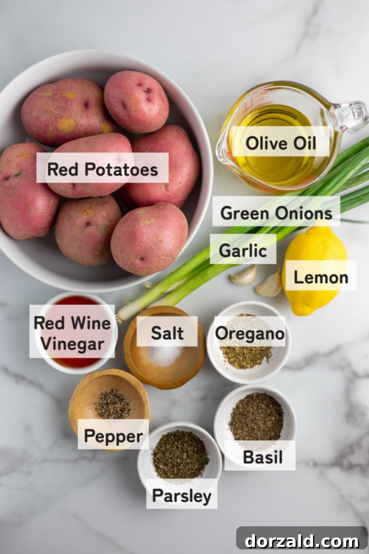 Close-up of fresh ingredients for Zoes Kitchen potato salad, including red potatoes, green onions, lemon, garlic, and herbs.