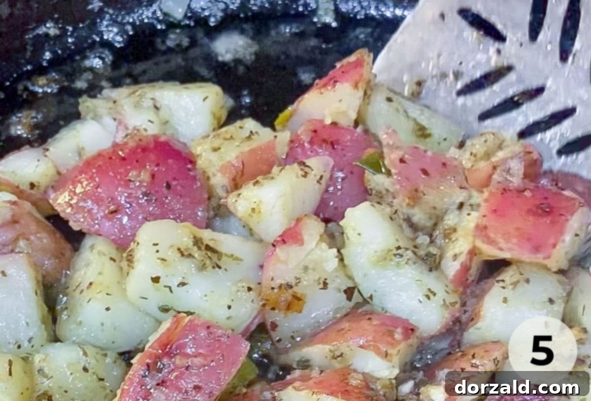 Close-up of grilled Zoes Kitchen copycat potato salad on a flat griddle, showing crispy edges.